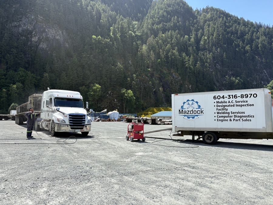 Mazdock Mechanical cube van and Freightliner semi on a BC mountain highway near Agassiz with Coast Range in the background